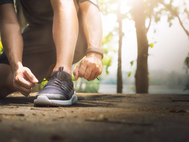 Young man runner tying shoelaces.